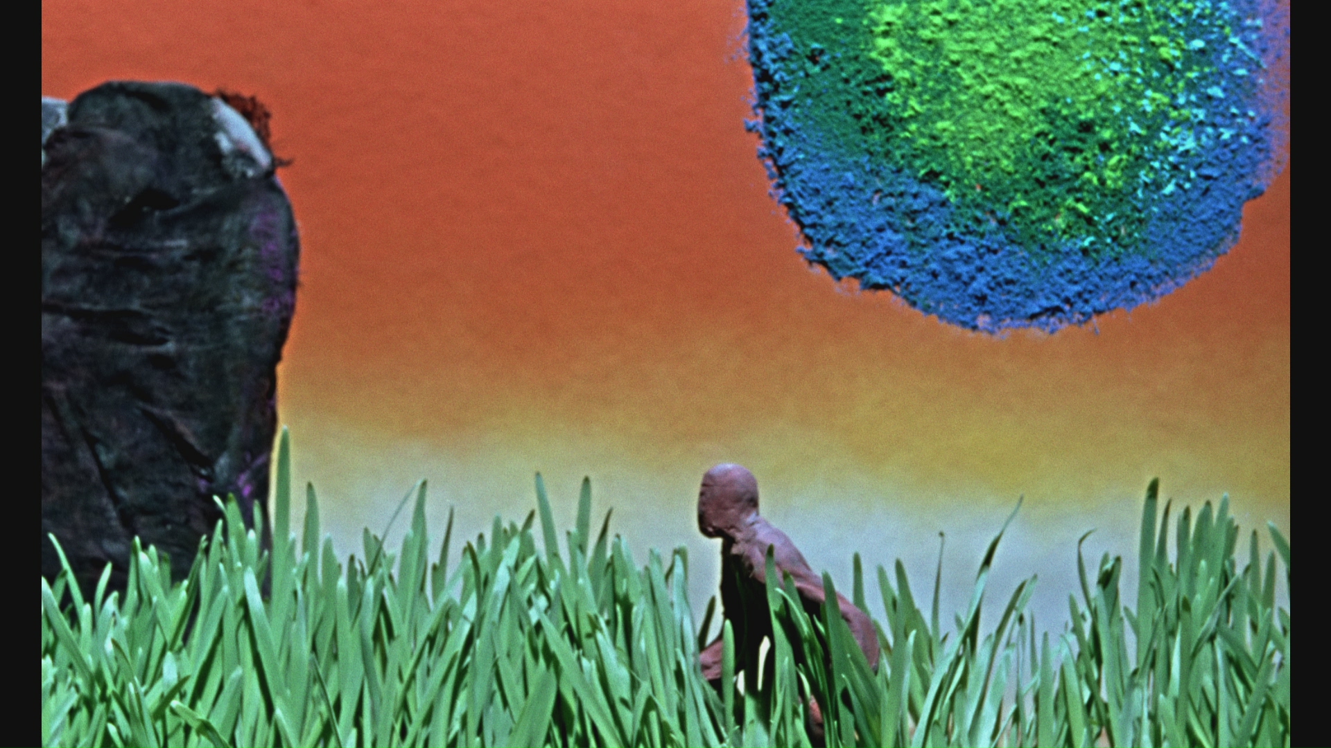 a small clay figure among tall grass